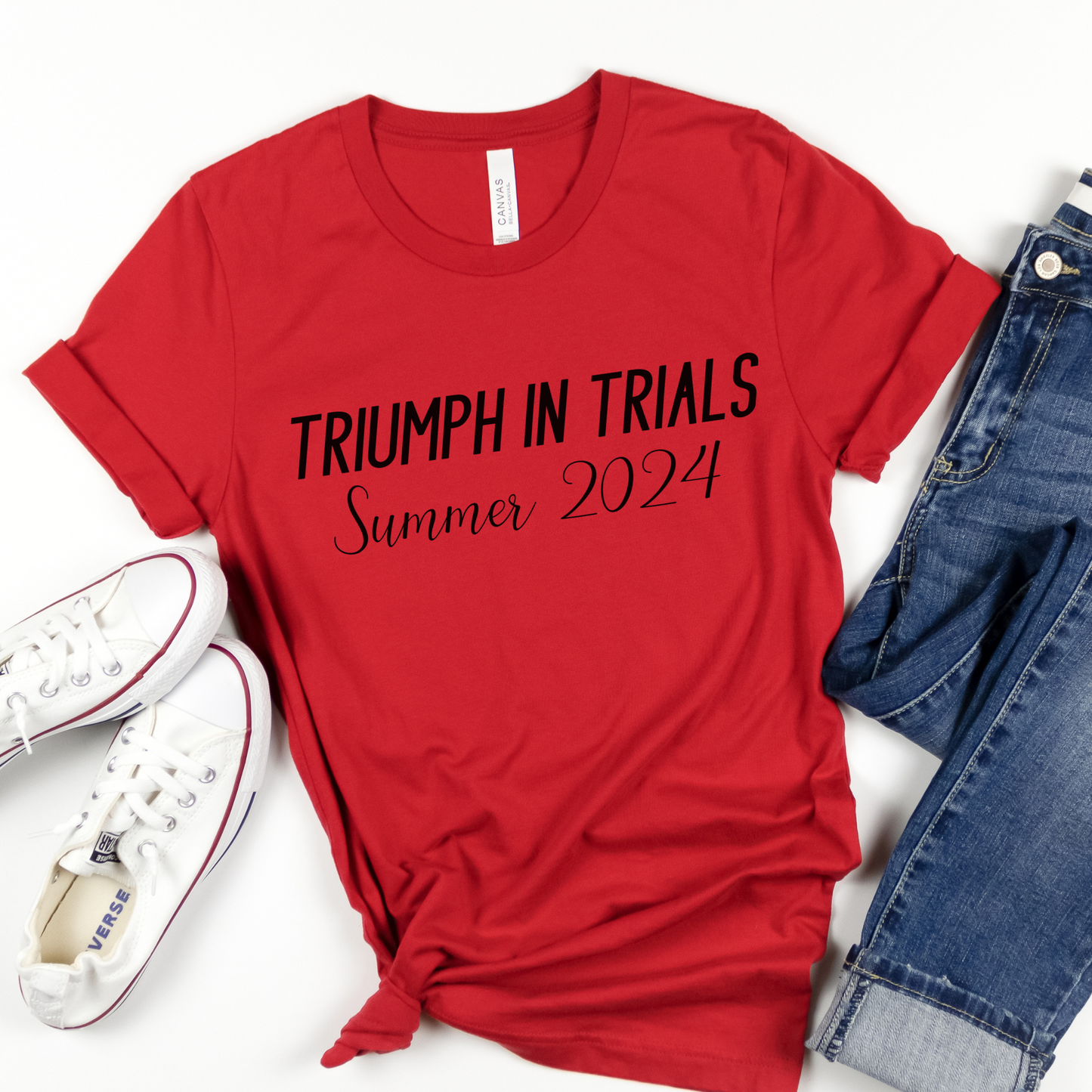 Red Cotton Tee reads, Triumph in Trials Summer 2024